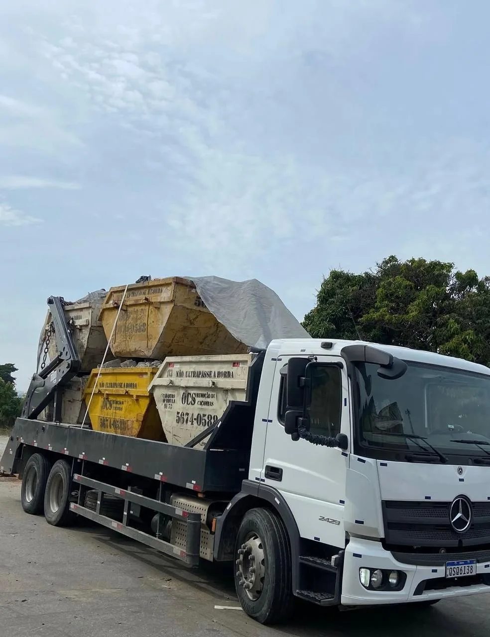 Caminhão Mercedes transportando caçambas